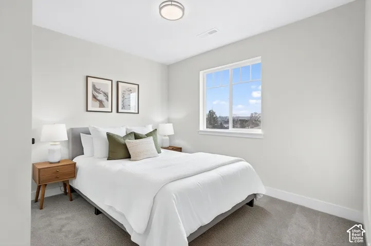 Light gray wall finish, window with white trim, gray carpet flooring, and a flush mount ceiling light
