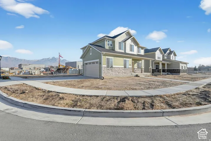 Two-story residence featuring light green siding and stone veneer accents