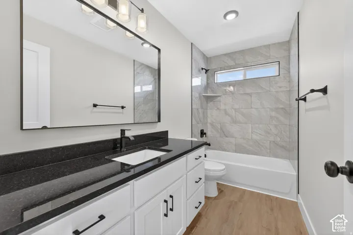Vanity with dark countertop, undermount sink, and matte black faucet