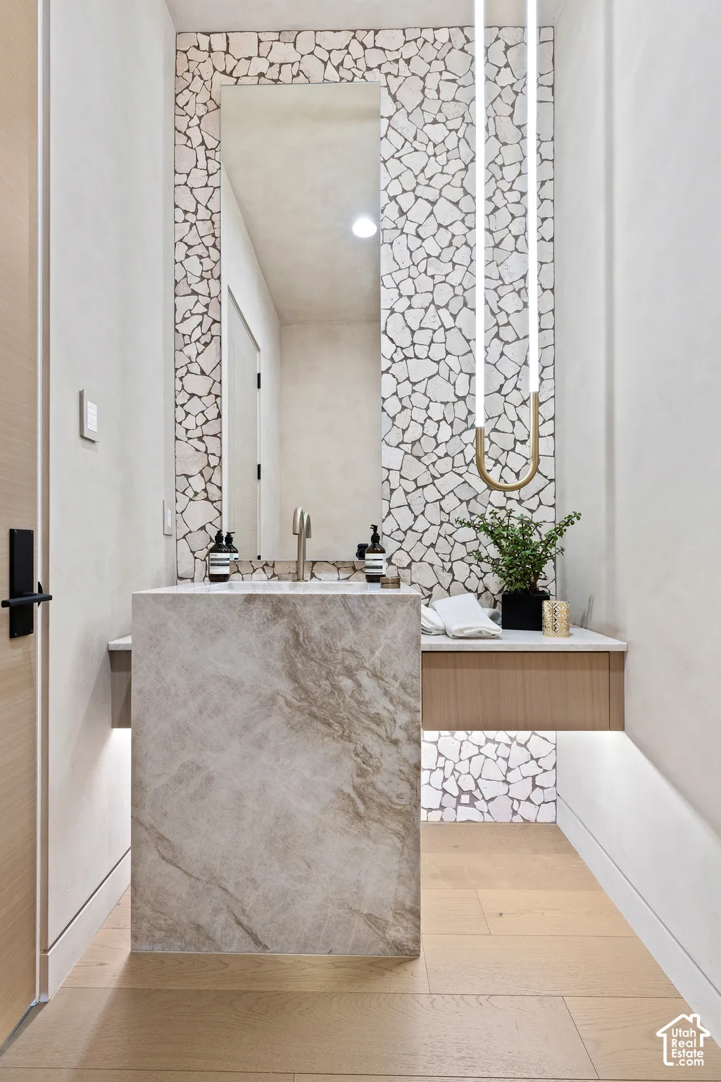Floor-mounted stone vanity with a wall-mounted faucet