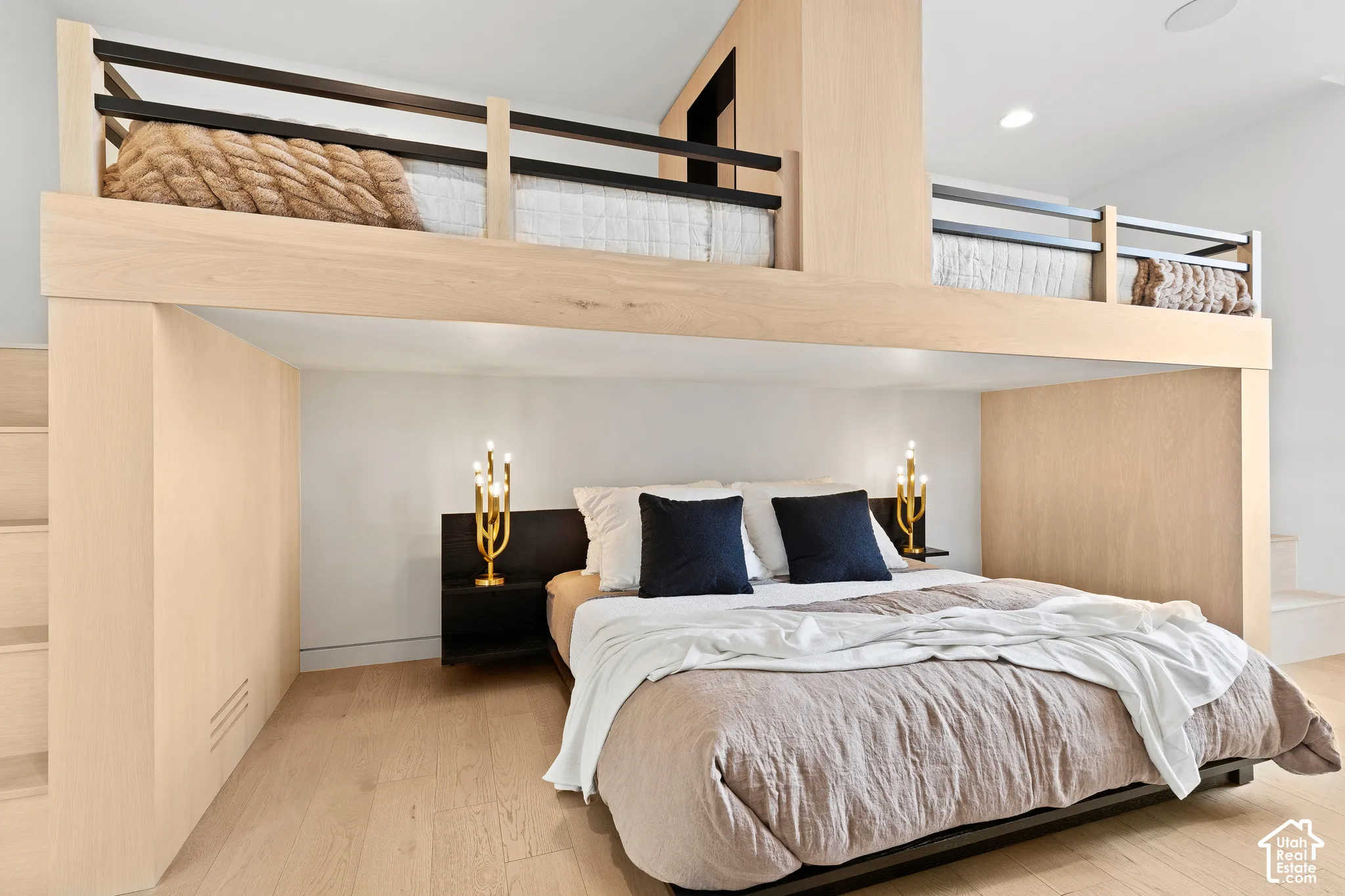 Lofted sleeping area with integrated storage, wood-finish flooring, recessed lighting, and a built-in nightstand