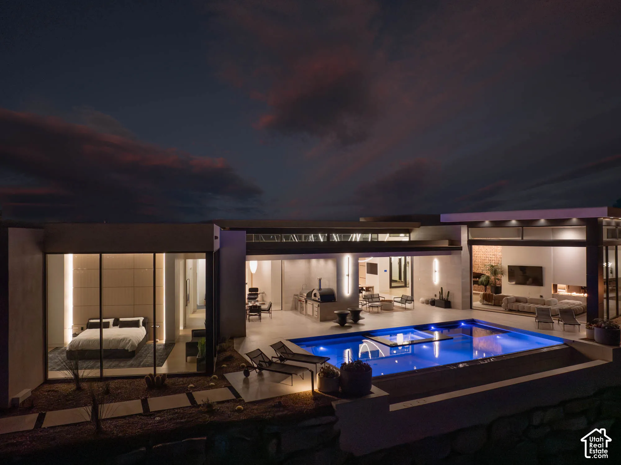 Outdoor swimming pool, built-in outdoor kitchen, integrated outdoor lounge area, expansive glass doors, modern architectural design