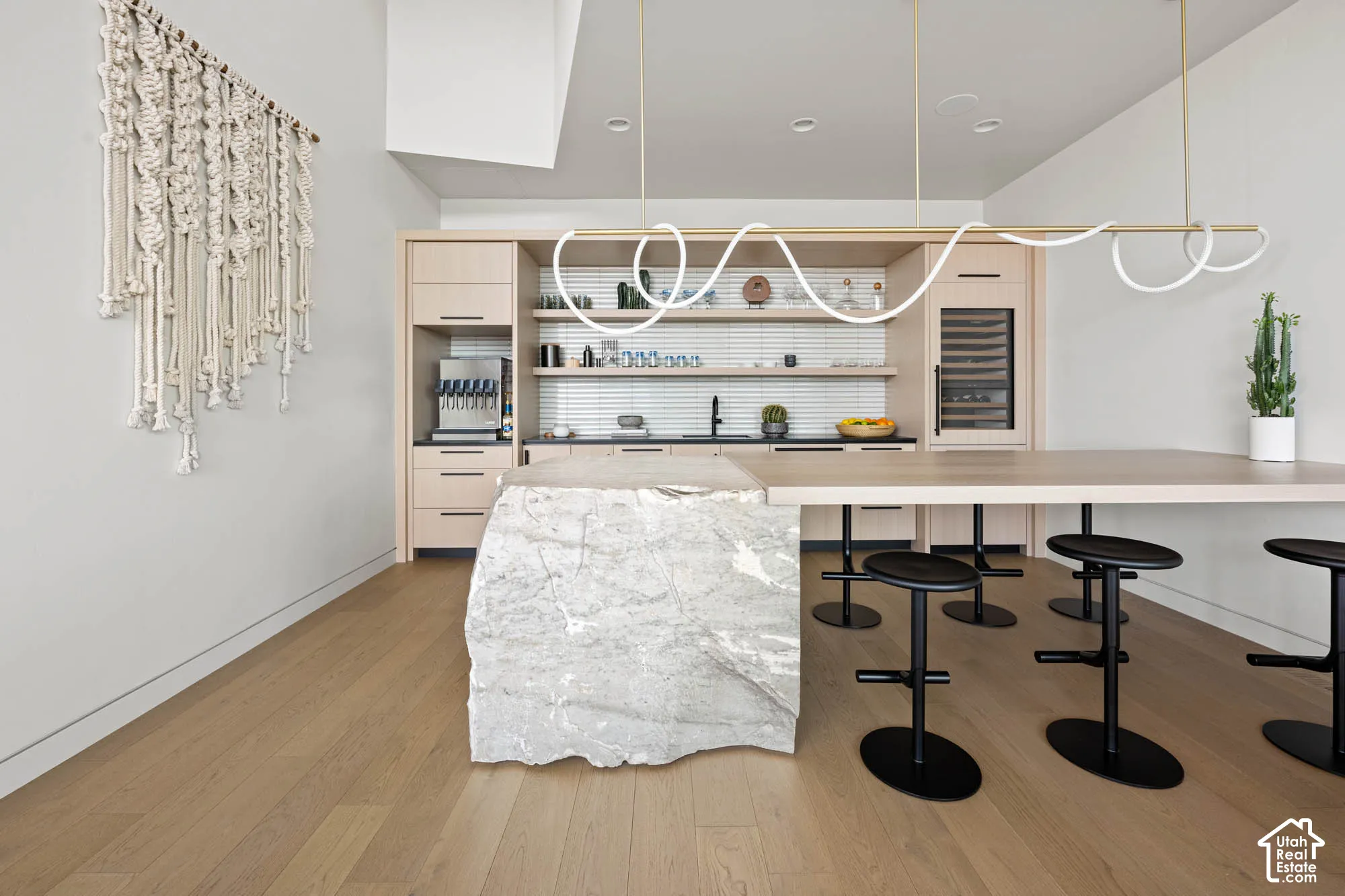Wood-finish flooring with a stone island base, integrated beverage dispenser, and built-in wine refrigeration