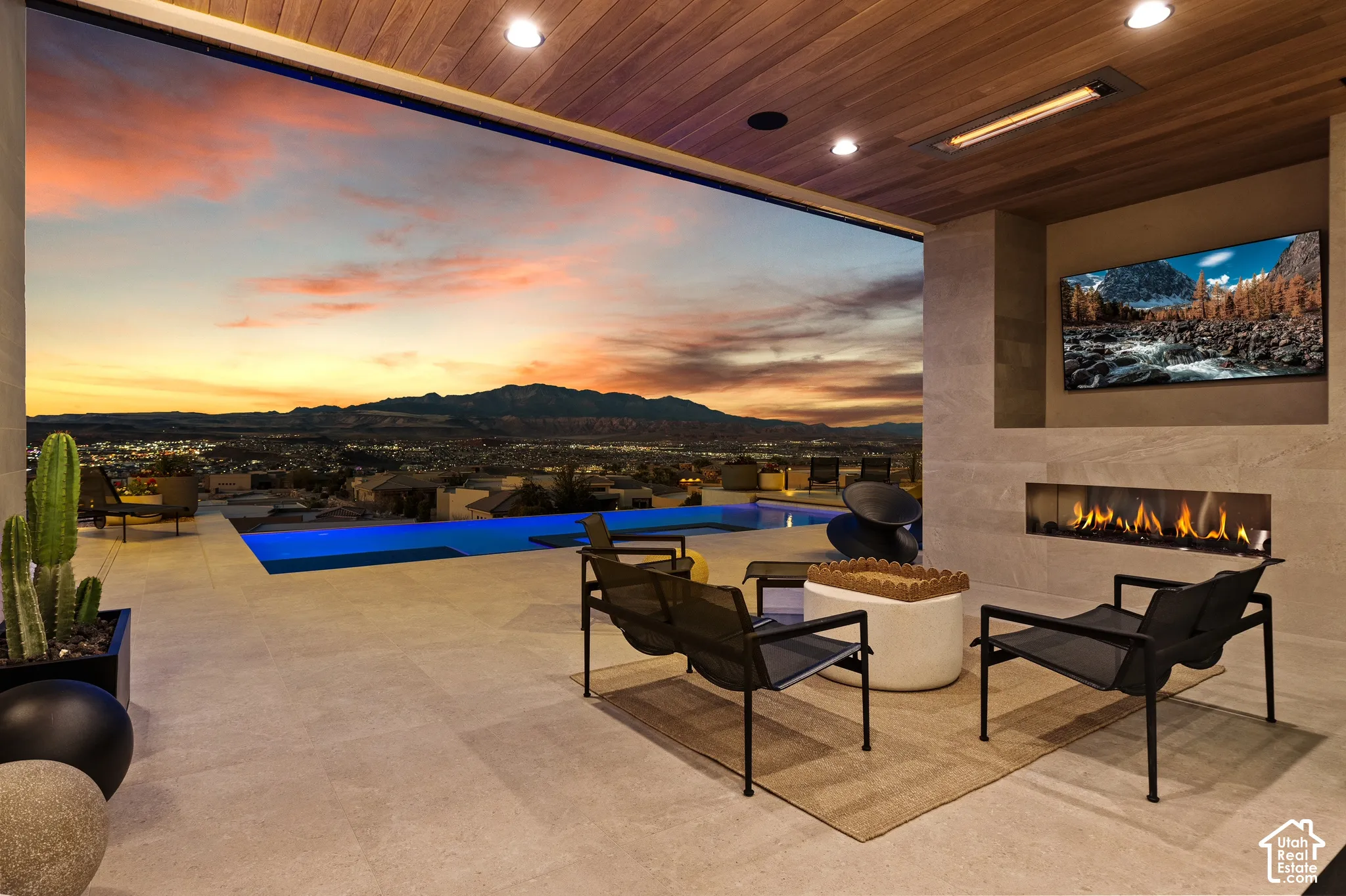 Expansive outdoor patio with a tiled floor, integrated fireplace, mounted television, and a built-in outdoor heater