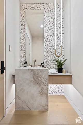 Floor-mounted stone vanity with a wall-mounted faucet