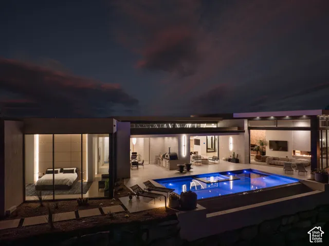 Outdoor swimming pool, built-in outdoor kitchen, integrated outdoor lounge area, expansive glass doors, modern architectural design