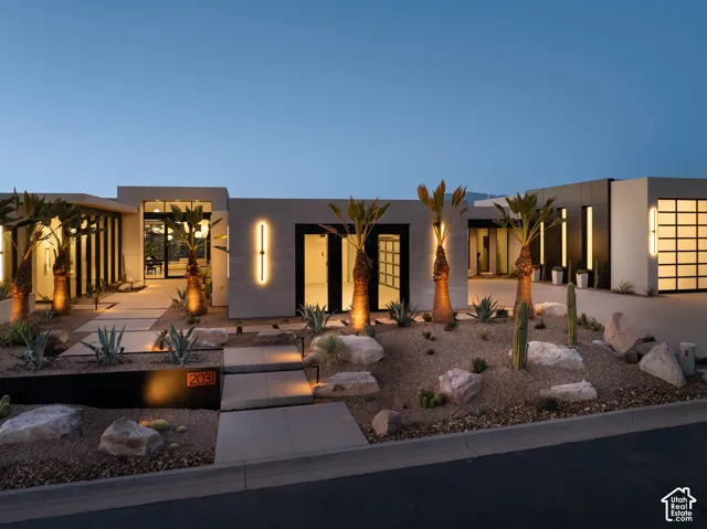 Contemporary exterior with a smooth stucco finish, desert landscaping, and a sectional glass garage door