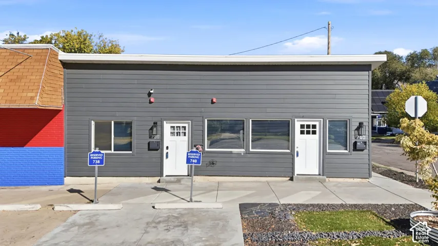 Modern exterior featuring gray siding, white trim, and white entry doors