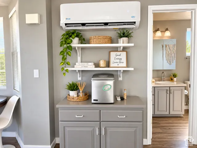 Wall-mounted ductless HVAC unit, built-in lower cabinetry with neutral solid-surface countertop, and two white floating shelves