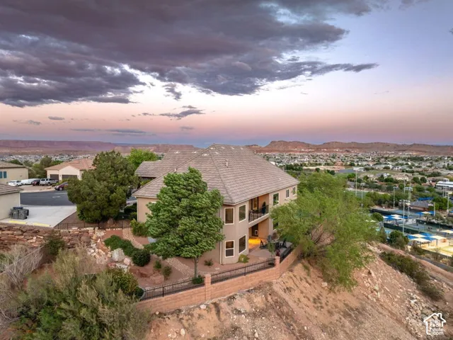 Two-story stucco exterior with multiple balconies, tile roof, and a fenced yard