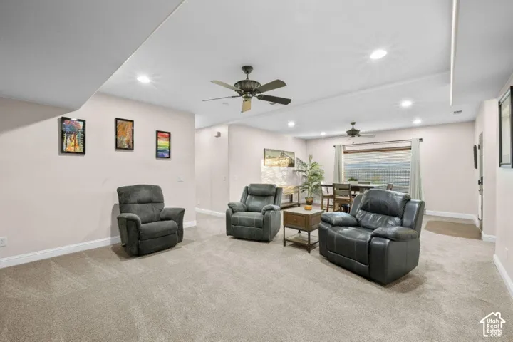Recessed lighting, ceiling fans, light-toned carpeting, and neutral wall tones define this expansive interior space