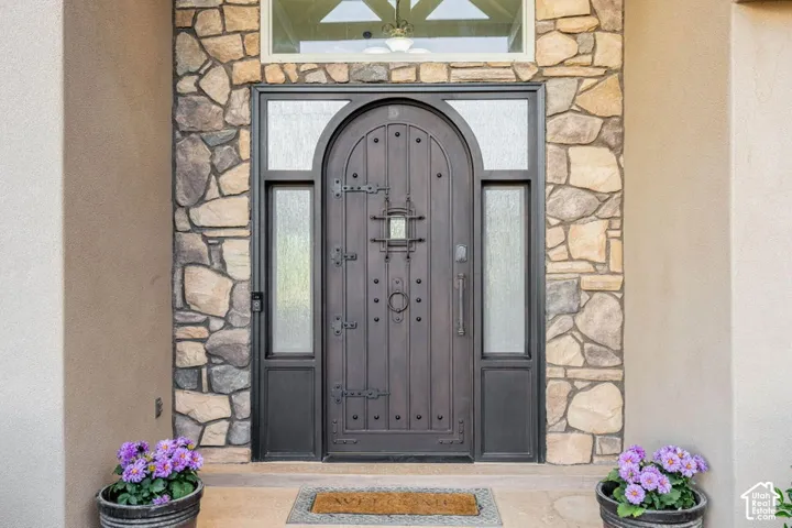 Arched entry door with decorative hardware, flanking sidelights, and an arched transom window