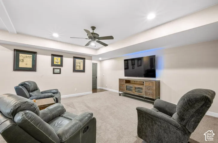 Recessed lighting, tray ceiling, ceiling fan, carpet flooring, and a built-in media console
