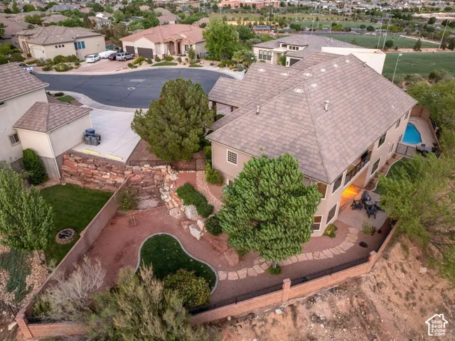 Multi-level residence featuring a pitched shingle roof, integrated swimming pool, and stone retaining walls