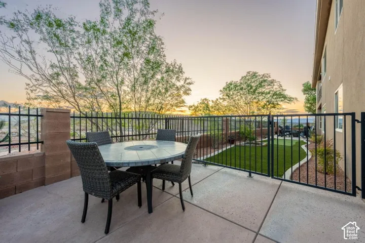 Concrete patio with a black metal fence and block wall