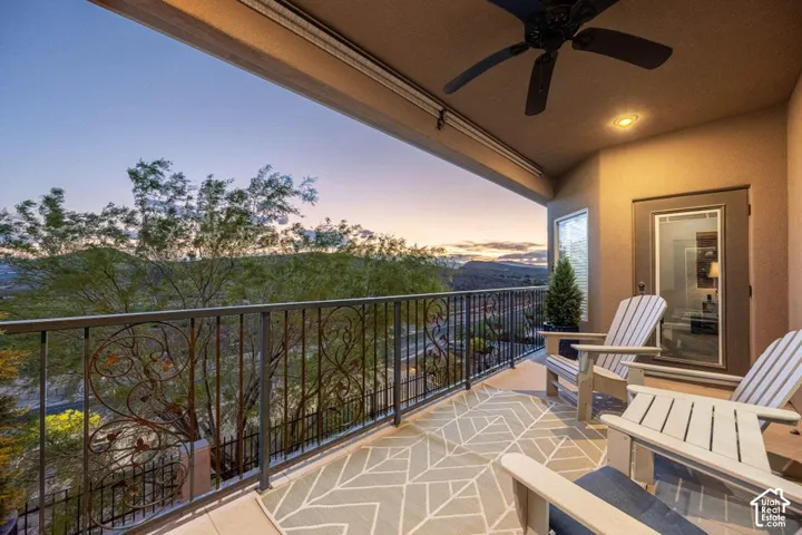 Covered balcony featuring an ornate wrought-iron railing, a ceiling fan, recessed lighting, and a patterned outdoor rug