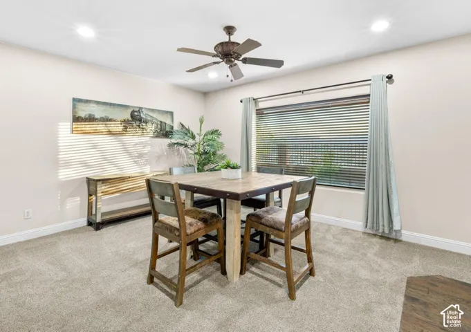 Recessed lighting, ceiling fan, neutral carpet, window with blinds, and window curtains