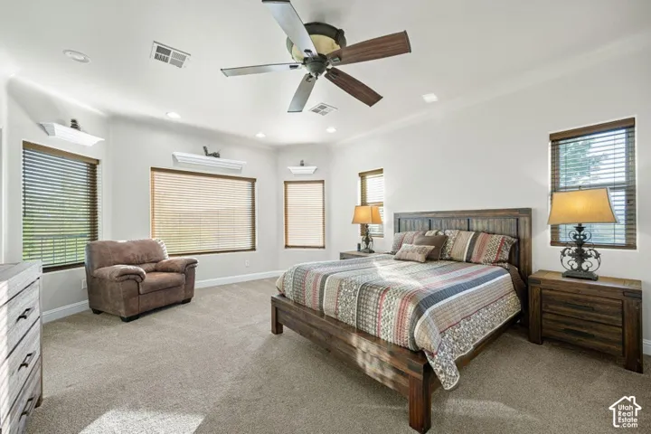 Carpeted bedroom featuring multiple windows with blinds, recessed lighting, and a ceiling fan