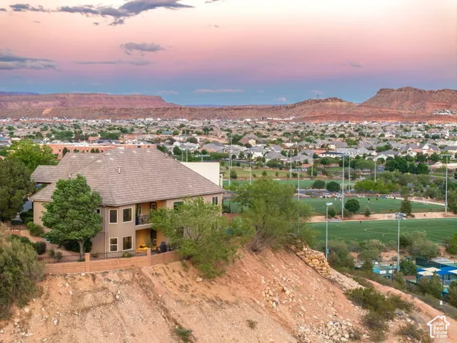 Terracotta tile roof with a stucco exterior, multiple balconies, and a partial retaining wall