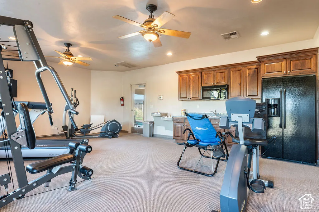 Full kitchen featuring wood-finish cabinetry, black appliances, and a stainless steel sink