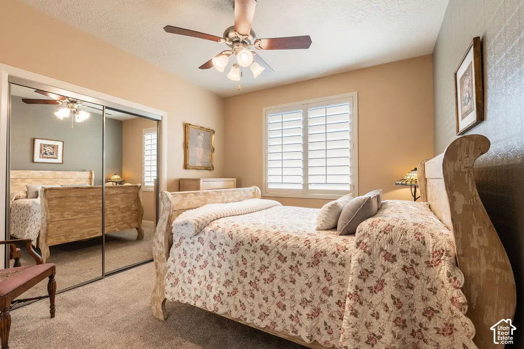 Neutral wall paint, ceiling fan with integrated lighting, window with white plantation shutters, and mirrored closet doors