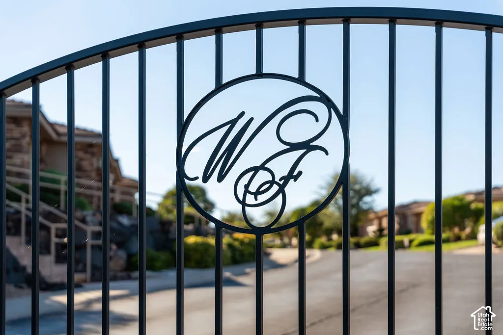 Wrought iron gate with custom scrollwork and a paved entry drive