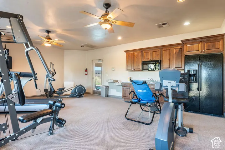 Full kitchen featuring wood-finish cabinetry, black appliances, and a stainless steel sink