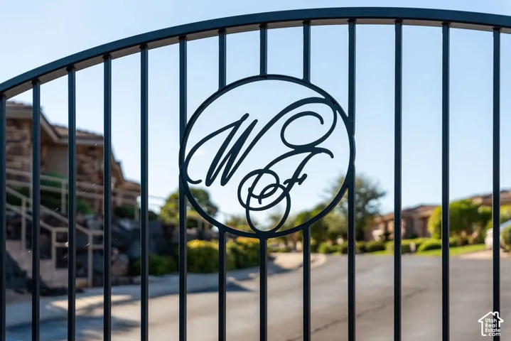 Wrought iron gate with custom scrollwork and a paved entry drive