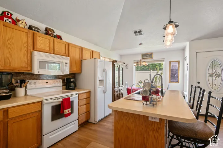 Kitchen featuring wood-finish cabinetry, solid surface countertops, a built-in microwave, and wood-finish flooring