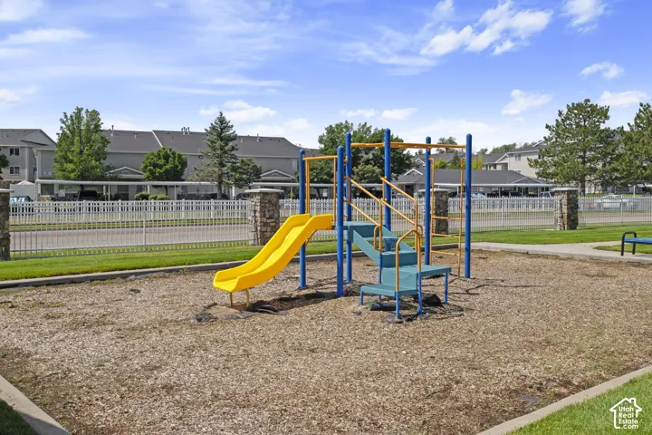 Community playground with a yellow slide and blue climbing structure