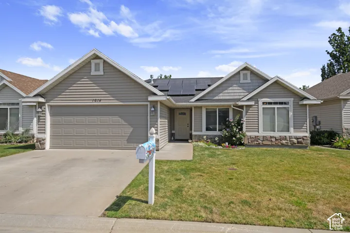 Single-story residence featuring light gray siding, a two-car garage, and a concrete driveway