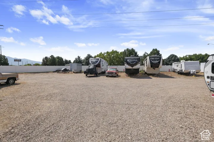 Gravel lot with perimeter fencing and distant mountain scenery