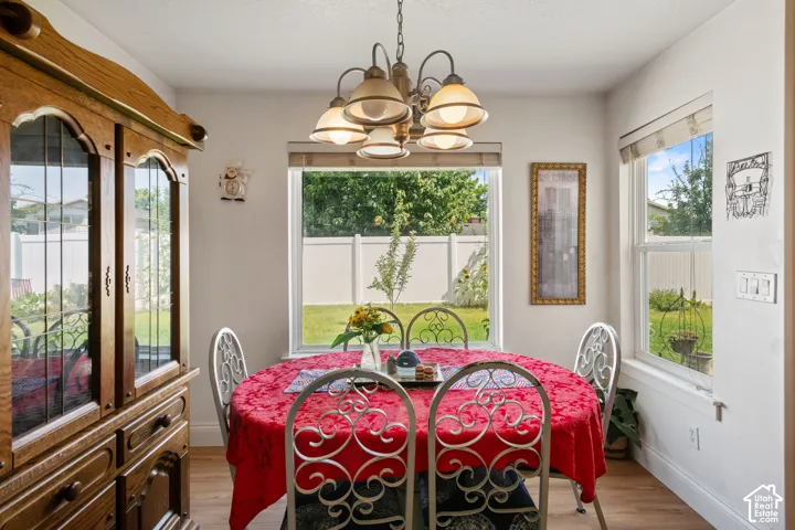 Hardwood-finish flooring, built-in display cabinetry, and a multi-light chandelier
