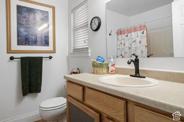 Vanity with a single basin sink and black-finish faucet, wood-finish cabinetry, and a full-width mirror