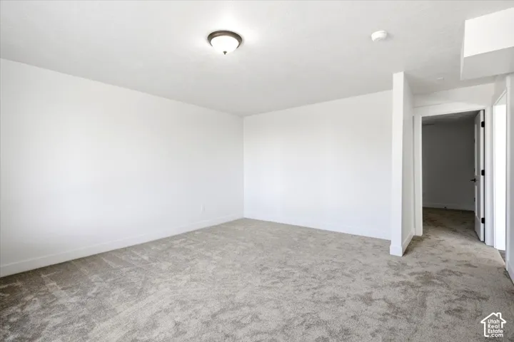 Recessed ceiling light fixture, neutral wall finishes, gray patterned carpeting, and white trim work