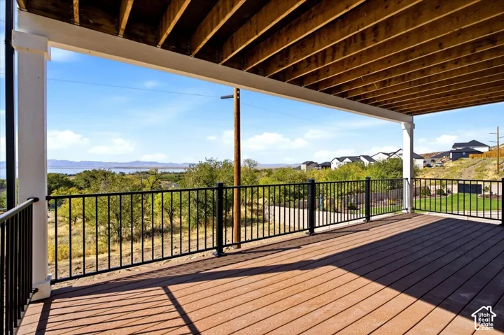 Expansive outdoor deck with composite decking, black metal railing, and a covered ceiling structure