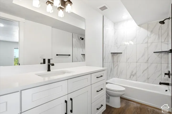 White shaker vanity with black hardware, white countertop, and dark-finish faucet