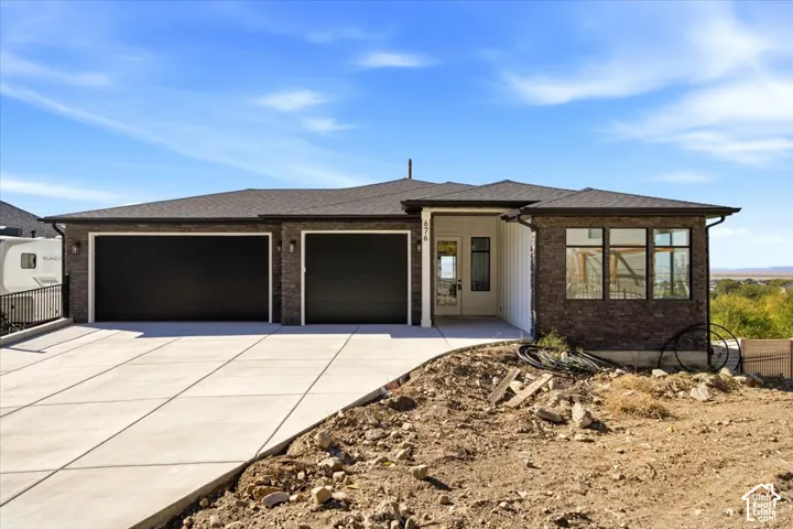 Contemporary exterior featuring stone accents, a dark shingle roof, dual black garage doors, a concrete driveway, and a covered entry