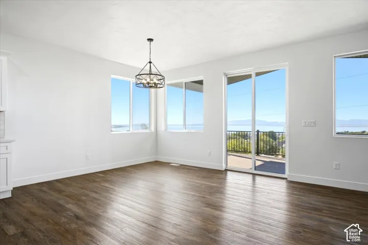 Wood-finish flooring, white walls, and a contemporary chandelier