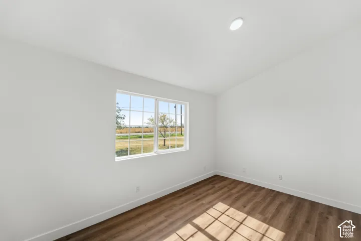 Recessed ceiling lighting, wood-finish flooring, and a large window with multiple panes