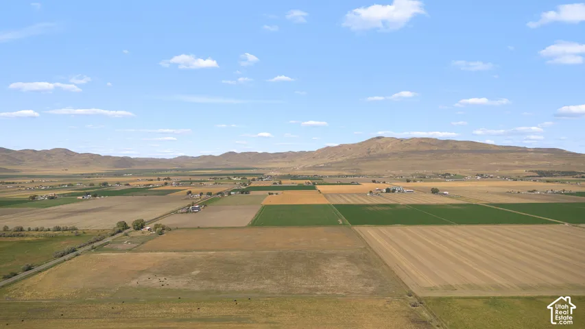 Expansive land featuring diverse agricultural fields and mountainous backdrop