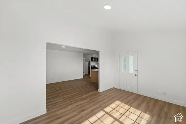 Wood-finish flooring, recessed lighting, and a paneled entry door with frosted glass inserts