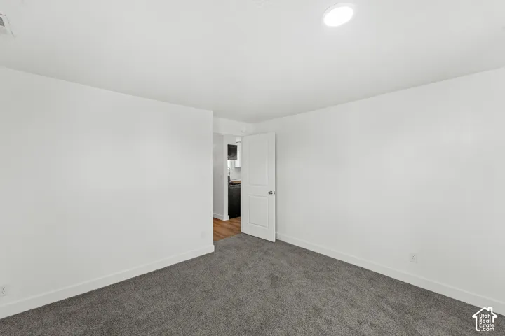 Recessed ceiling lighting, gray carpeting, white walls, and white trim