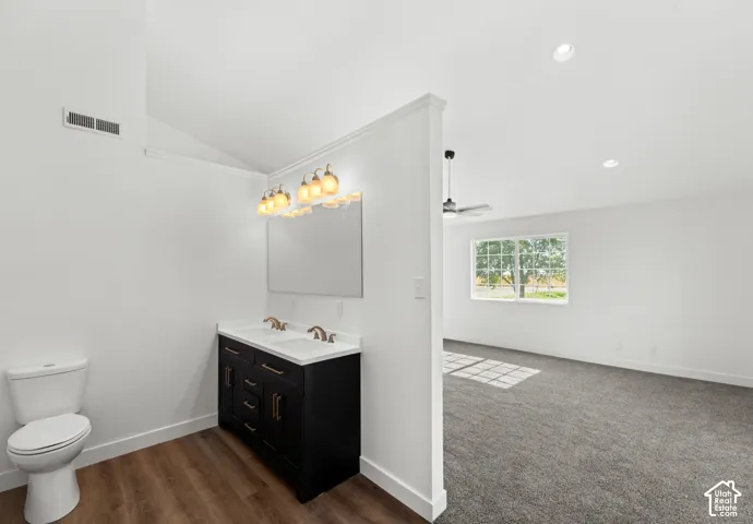 Dual vanity with black cabinetry, wood-finish flooring, recessed lighting, and ceiling fan