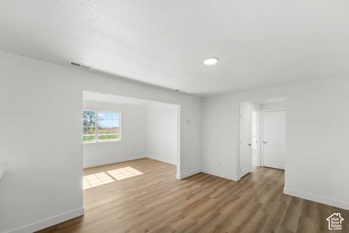 Open concept living space with wood-finish flooring, recessed lighting, and white trim