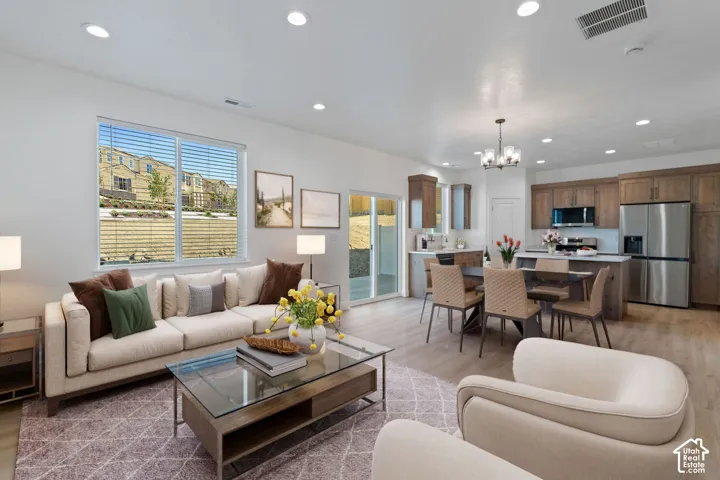 Open-concept living space featuring wood-finish flooring throughout, recessed lighting, and a modern kitchen with stainless steel appliances