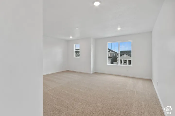 Spacious room featuring neutral carpeting and white wall finishes