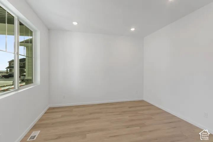 Recessed ceiling lighting, wood-finish flooring, and a large multi-pane window