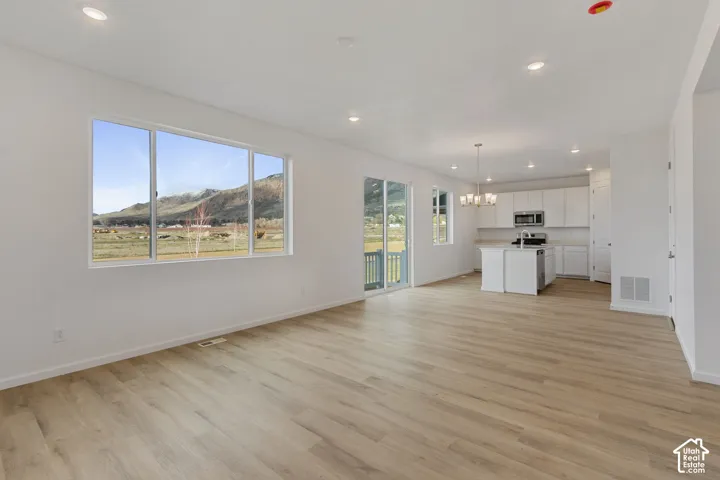Expansive open-concept living area featuring wood-finish flooring, recessed lighting, and large windows