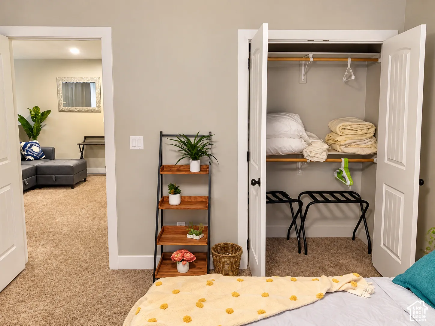 Interior doorway featuring white casing and a walk-in closet with double doors, overhead shelving, and a built-in hanging rod